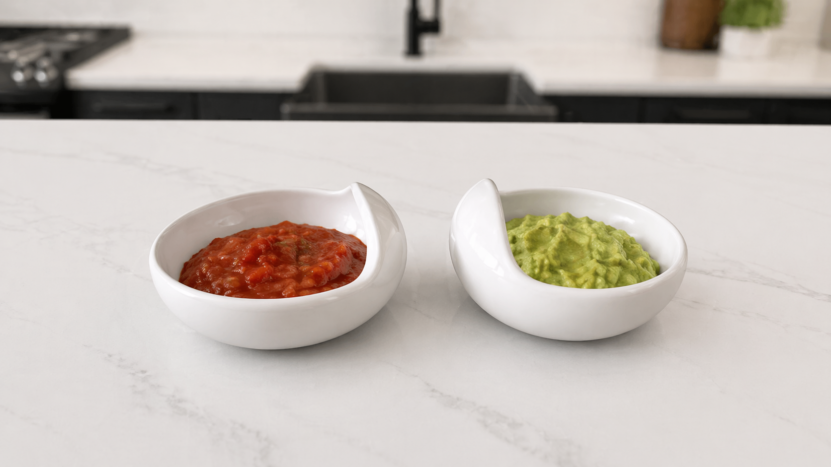 Two Palada bowls filled with salsa and guacamole on a marble countertop